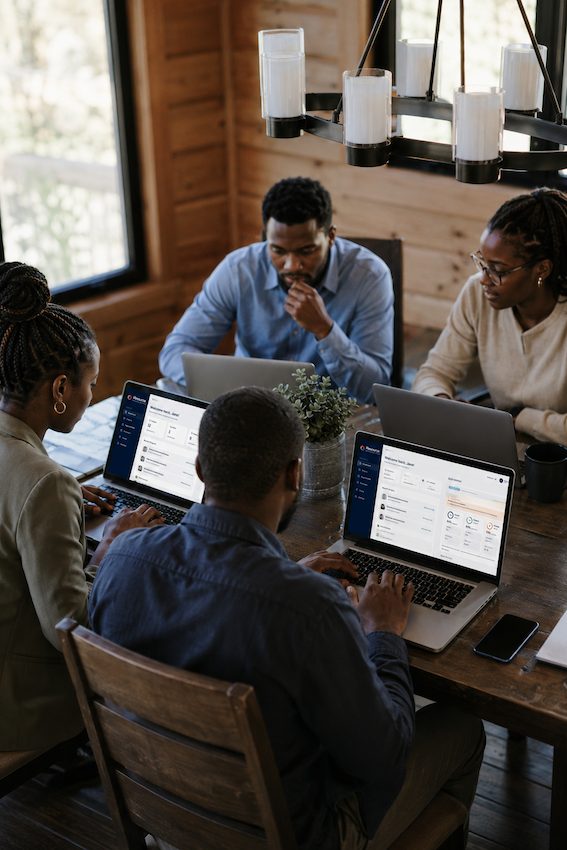 African professionals collaborating on laptops in a shared workspace